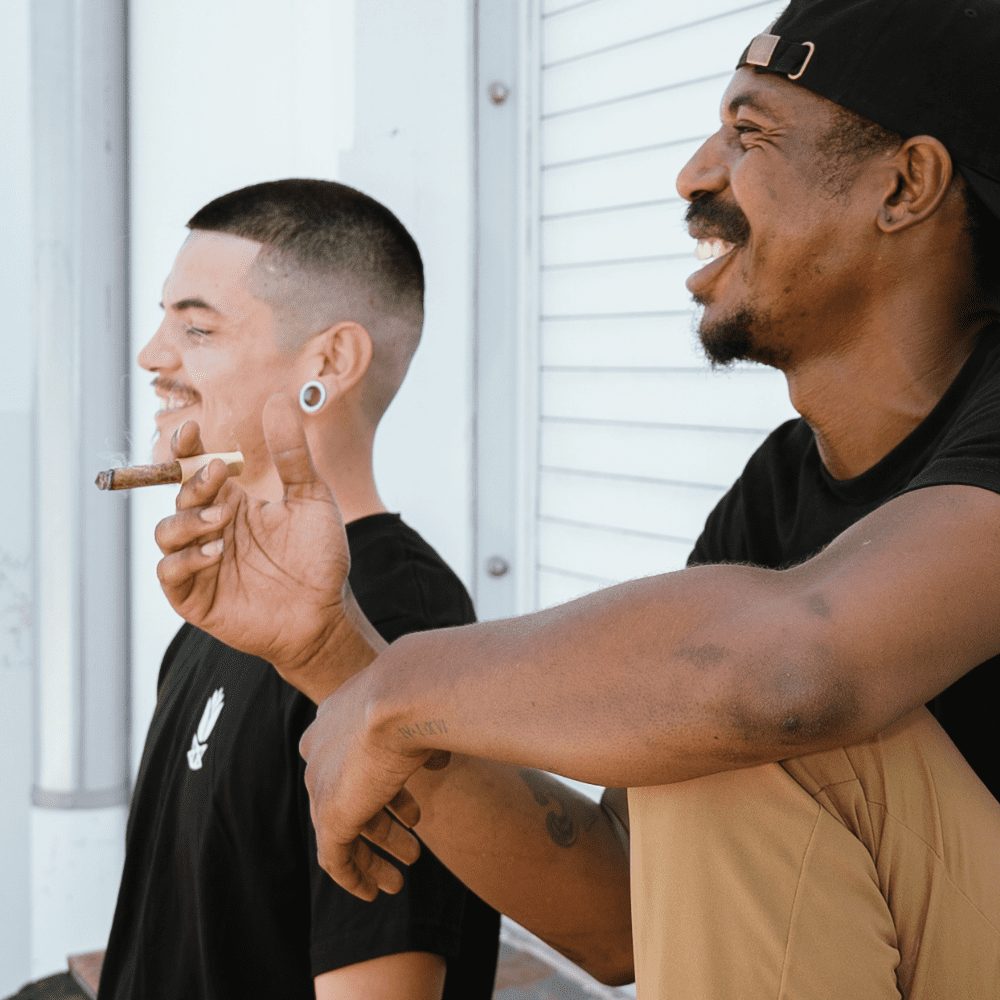 Man holding a cigar, smiling, showcasing Small CannaMold - Fits 3.5-7g, designed for creating slow-burning, tightly packed cannagars for extended smoking sessions.