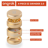 4pcs Aluminum 2.6 EZ Grinder with a gold finish, featuring a metal lid, triangular teeth, and deep chambers for grinding and storing herbs.