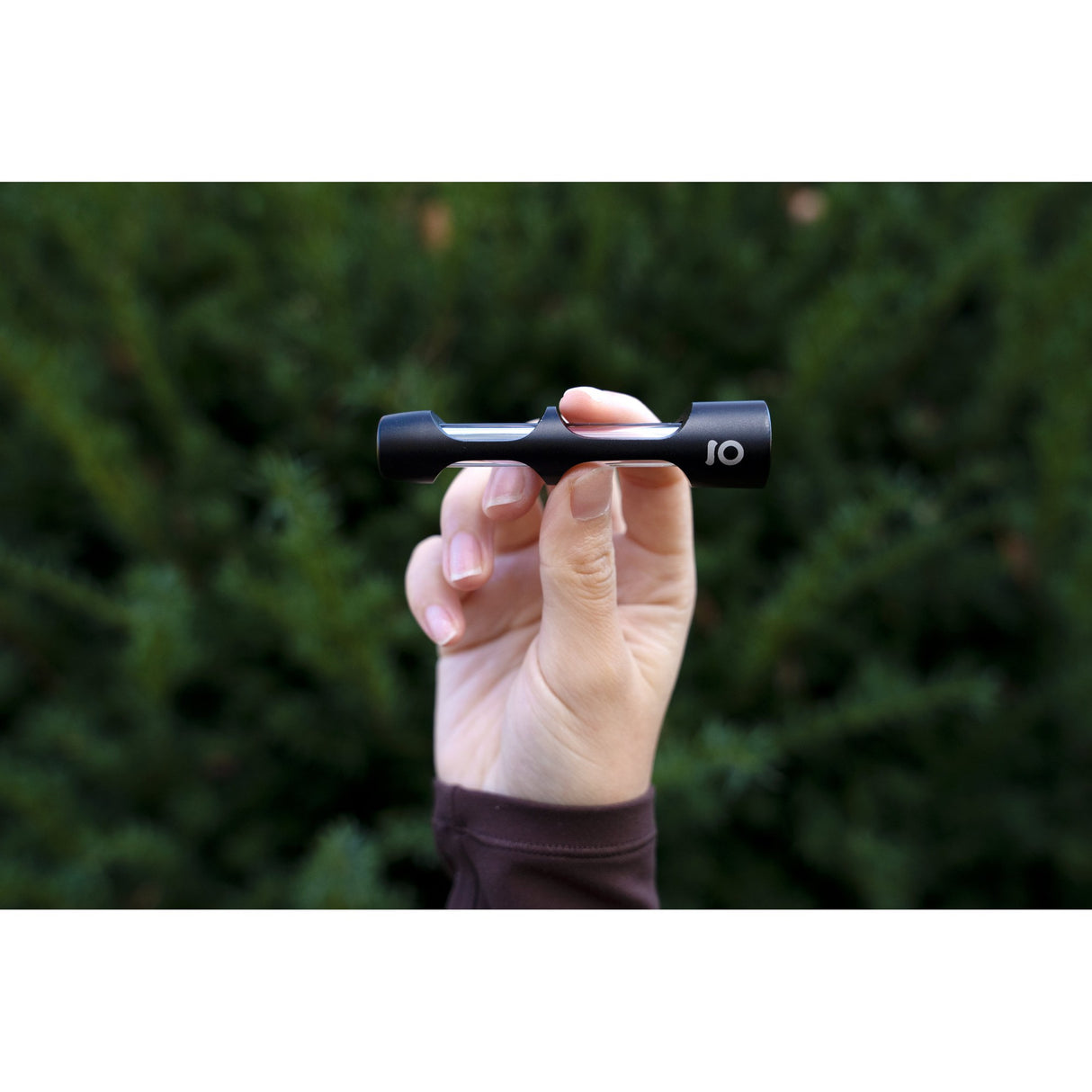 Hand holding the Aluminum & Glass Chillum One Hitter, showcasing its sleek, black anodized aluminum exterior, ideal for discreet, portable smoking sessions.