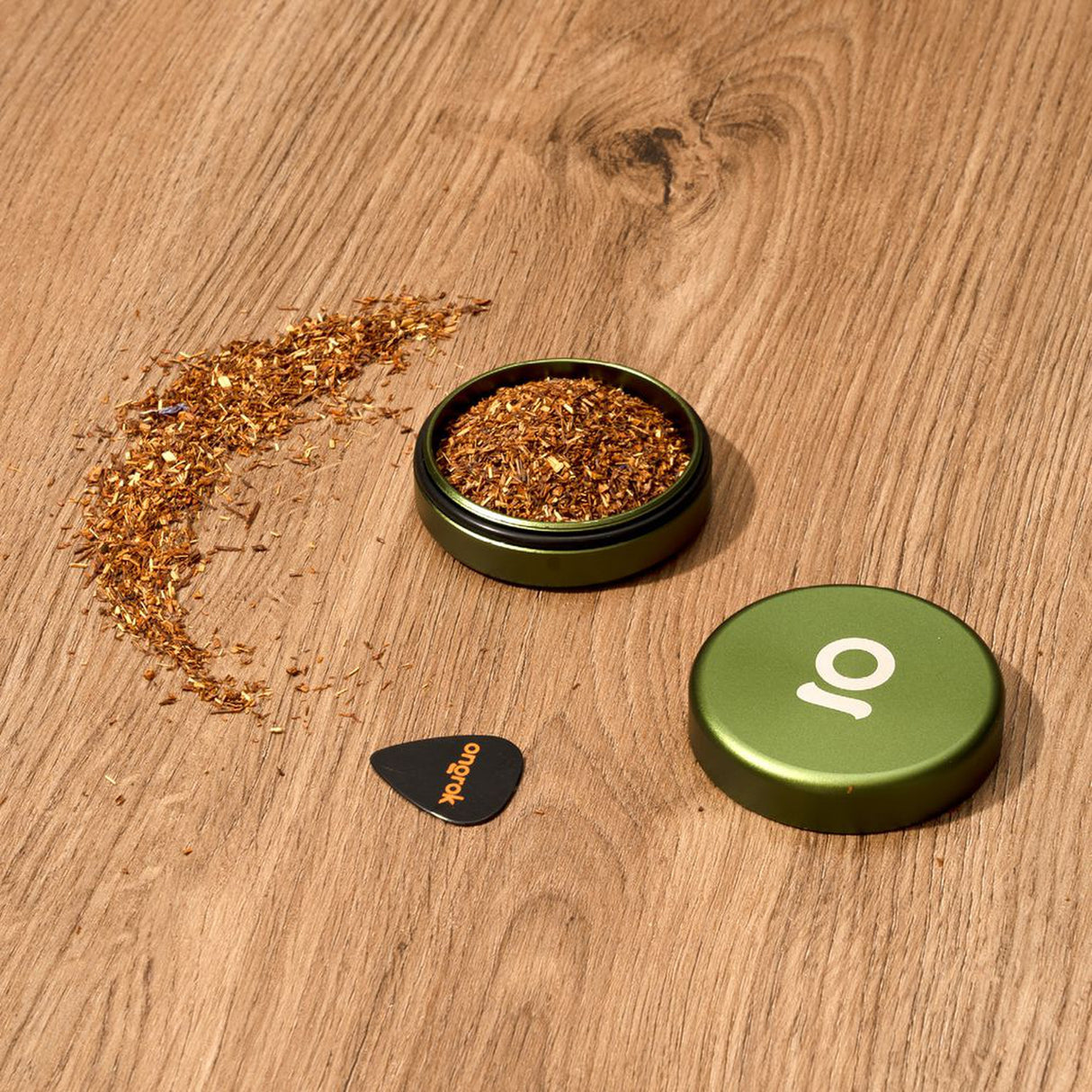 Aluminum Storage Puck with airtight seal, shown with wood shavings and a plectrum, ideal for discreet, on-the-go storage.