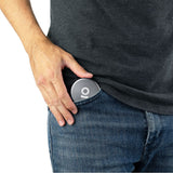 Person placing an Aluminum Storage Puck into a jeans pocket, illustrating its compact, discreet size for convenient, on-the-go storage.