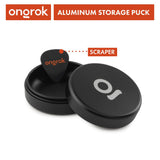 Aluminum Storage Puck, a black round container featuring a guitar pick, designed for discreet, airtight storage with an interchangeable system. Ideal for on-the-go use.