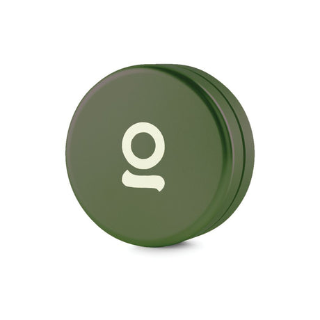 Aluminum Storage Puck, a green circular container with a white letter, designed for on-the-go storage, featuring an airtight seal to prevent odor escape.