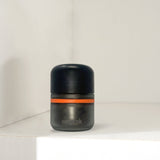 Child Proof Storage Jar 80ml - 6 Pack, featuring a black cylindrical container with an orange band, designed for secure, organized herb storage.