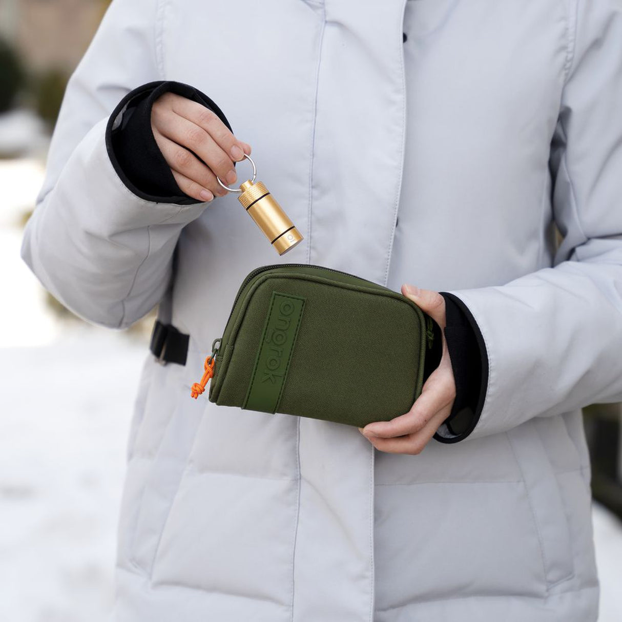 Person holding the Smell Proof Water-Resistant Wallet with a keychain, showcasing its compact design ideal for securing valuables.