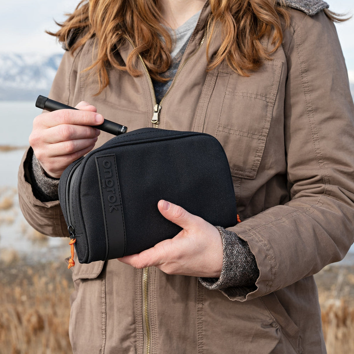 Smell Proof Water-Resistant Wallet held by a woman, showcasing its compact size and secure design, ideal for organizing and protecting personal belongings.