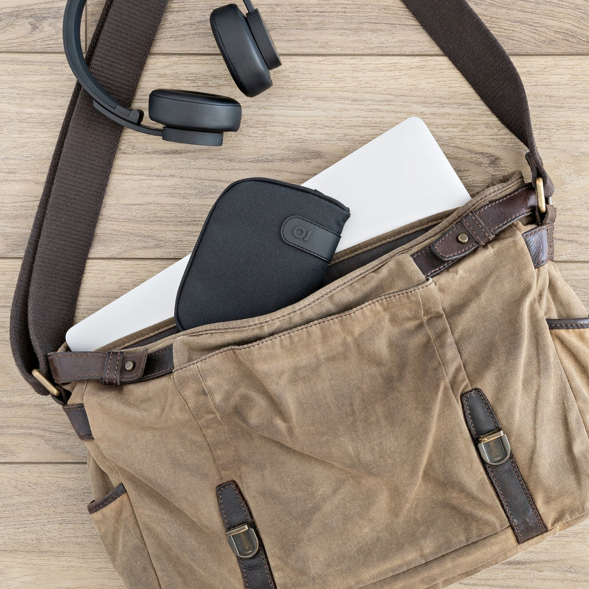 Smell Proof Water-Resistant Wallet with a laptop and headphones inside, featuring a zipper and a buckle for secure, organized storage.