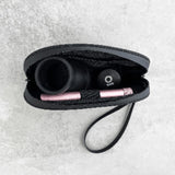 Smell Proof Water-Resistant Wrist Bag - Black, shown with a black case and headphones, featuring a detachable strap and mesh pocket for organization.