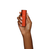 Hand holding the PAX Mini Dry Herb Vaporizer, showcasing its compact design ideal for efficient, portable vaping with simple, one-button operation.