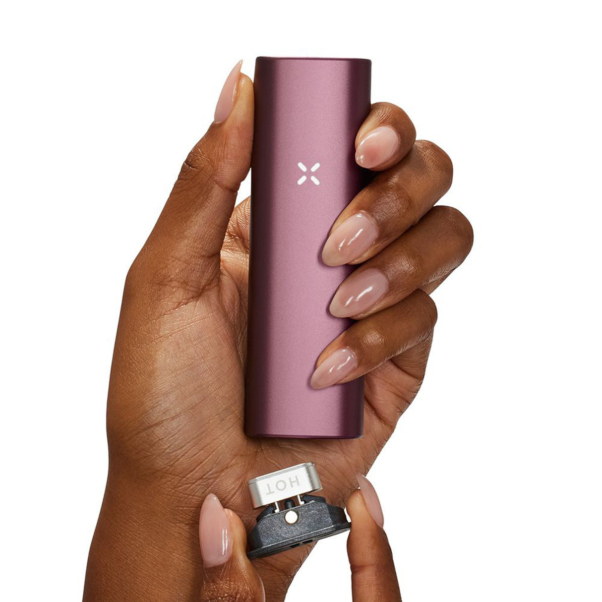 A hand holds the PAX Plus Dry Herb Vaporizer, showcasing its compact design with dual-use functionality, ideal for on-the-go vaping enthusiasts.