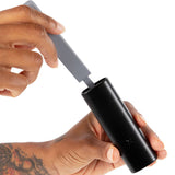 PAX Prep Tongs held in hand, showcasing its compact design ideal for vaping, featuring a silicone tamp and built-in tool for efficient flower management.