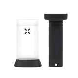 PAX Puck Press, a black cylindrical tool with a white lid, designed for pressing ground material into dense pucks for PAX devices.