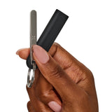 Hand holding the PAX Rounded Multi-Tool with keychain attachment, designed for easy packing and removing material from PAX Mini and PAX Plus devices.