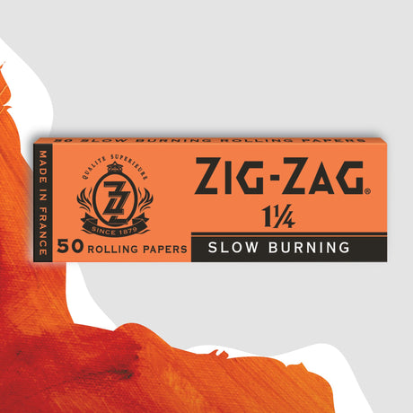 Zig-Zag 1 1/4 Orange Rolling Paper box featuring a logo and text, designed for a smooth, slow burn with natural flax plant fibers.