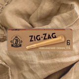 Pre Rolled Unbleached 1 1/4 Paper Cones - Pack of 6, displayed in a crush-proof slide box on a cloth surface.